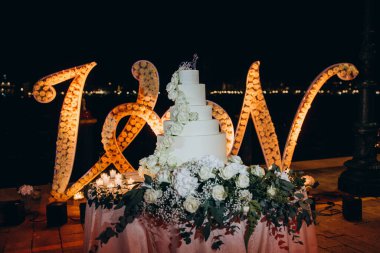 Geceleri gül ve mumlarla düğün pastası.     