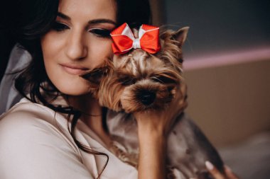 Güzel, genç bir gelin ve evde küçük sevimli bir köpek var.       