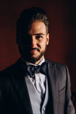 Zarif takım elbiseli ve papyonlu yakışıklı genç damat portresi.     