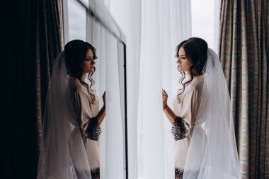 Gelin odada poz veriyor ve sabahları aynaya bakıyor.