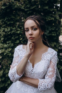 Gelinlikli güzel gelin parktaki kameraya bakıyor.