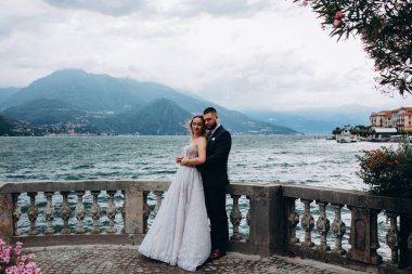 Güzel, mutlu, genç bir çift göl kenarında kucaklaşıyorlar.              