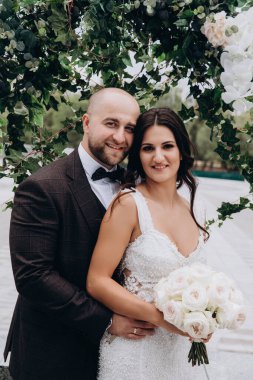 Güzel mutlu gelin ve damat parkta kucaklaşıyorlar.      