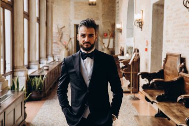 Zarif takım elbiseli ve papyonlu yakışıklı genç damat portresi.     