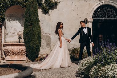 Güzel bir düğün çifti el ele tutuşuyor ve dışarıda yürüyor. 