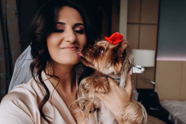 Güzel, genç bir gelin ve evde küçük sevimli bir köpek var.       