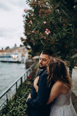 Güzel mutlu gelin ve damat parkta kucaklaşıyorlar.      