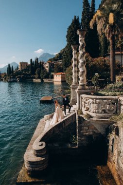 Güzel bir düğün çifti el ele tutuşuyor ve dışarıda yürüyor.  