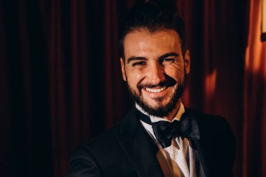 Zarif takım elbiseli ve papyonlu yakışıklı genç damat portresi.     