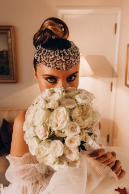 Beyaz gelinlik içinde bir buket tutan güzel gelin.    