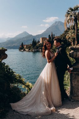 Güzel, mutlu, genç bir çift göl kenarında kucaklaşıyorlar.              