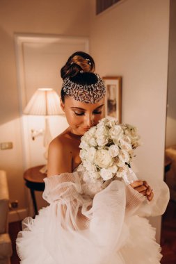 Beyaz gelinlik içinde bir buket tutan güzel gelin.    