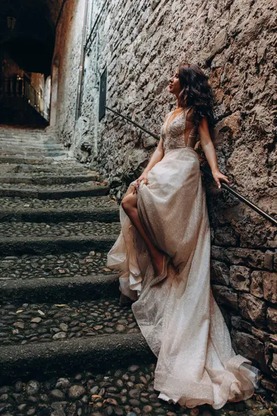 Gelinlikli güzel gelinin portresi. Eski kasabadaki merdivenlerde poz veriyor.                       