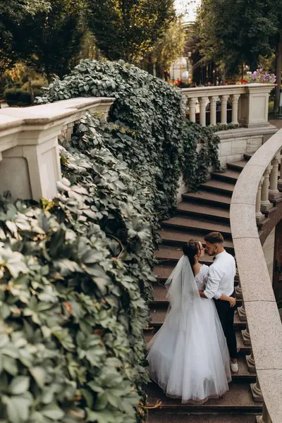 gelin ve damat sonbahar parkında. Merdivenlerde yürüyen çift.