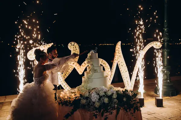 Düğün pastası kesen genç ve güzel bir çift. 