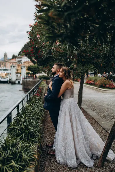 Deniz kıyısında sarılan mutlu genç çiftin yan görüntüsü