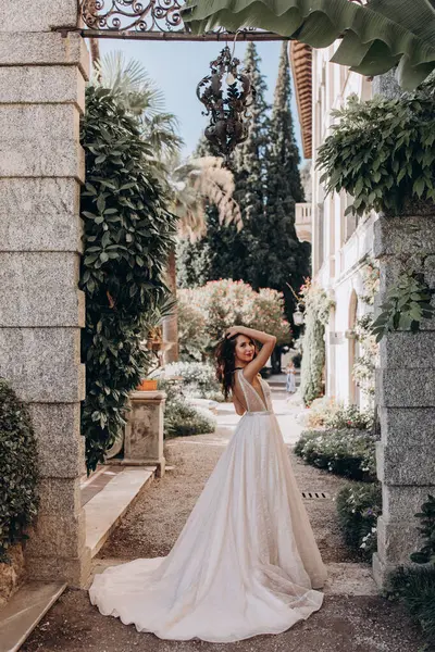 Beyaz gelinlikli güzel gelin eski kasaba caddesinde poz veriyor.                