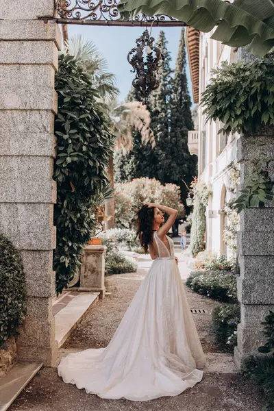 Beyaz gelinlikli güzel gelin eski kasaba caddesinde poz veriyor.                