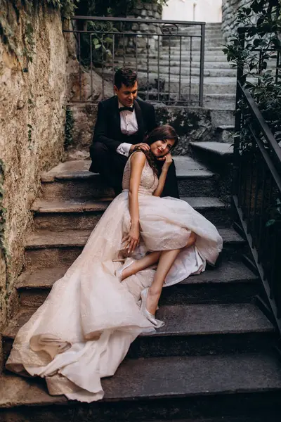 Eski kasabadaki merdivenlerde poz veren mutlu genç bir çiftin portresi.                           