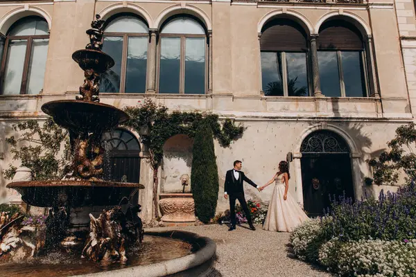 Güzel, genç bir çift eski evin önünde poz veriyor..