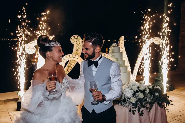 Düğün töreninde kadehleri tutan mutlu gelin ve damat