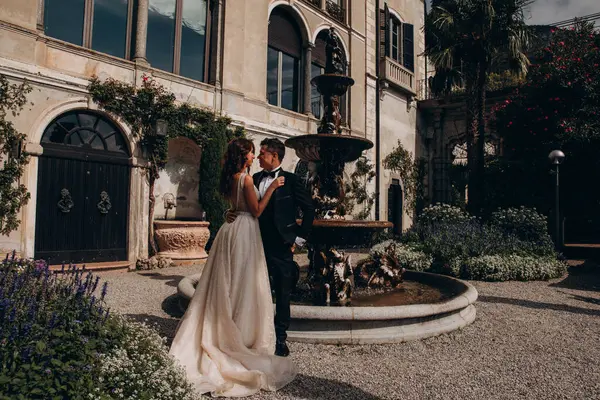 Mutlu gelin ve damat eski kasabada kucaklaşıp poz veriyor.