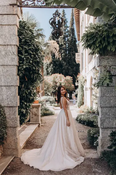 Beyaz gelinlikli güzel gelin eski kasaba caddesinde poz veriyor.                