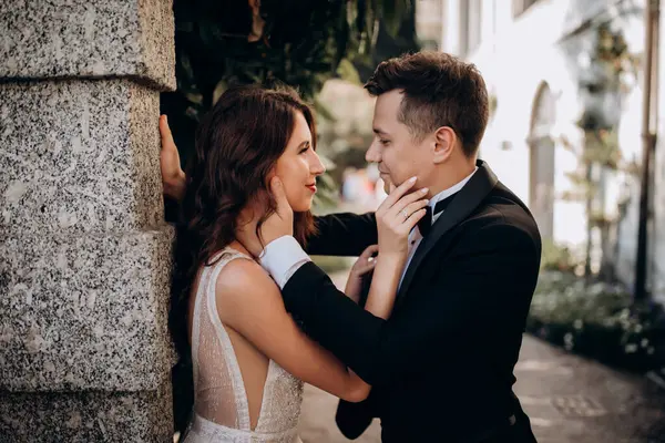 Güzel, mutlu, genç bir çift eski şehrin sokaklarında poz veriyor.           