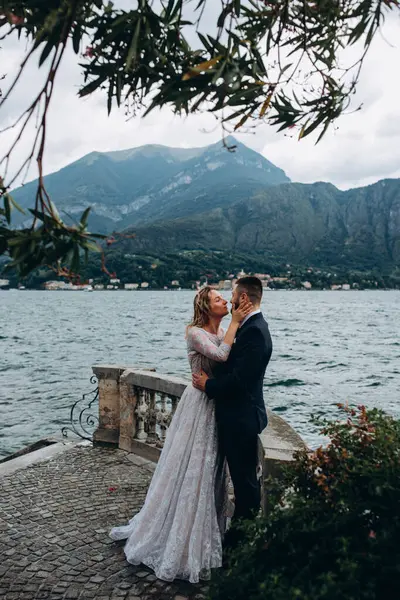 Güzel, mutlu, genç bir çift dağ gölü kenarında sarılıyor.  