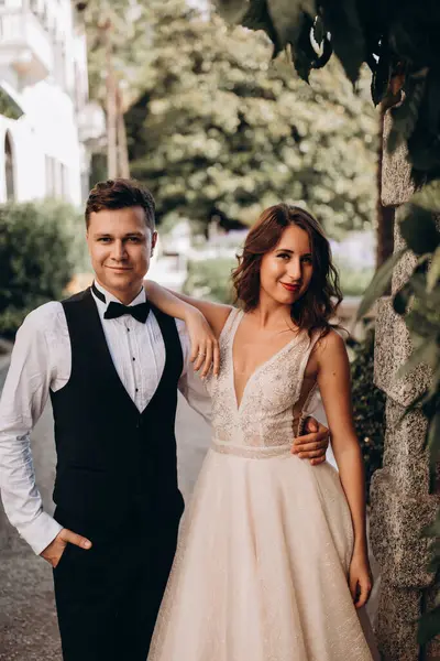 Güzel, mutlu, genç bir çift eski şehrin sokaklarında poz veriyor.           