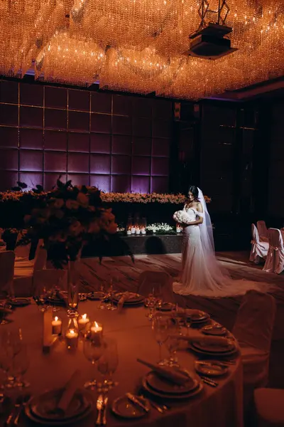 Restoranın arka planında çiçekler olan beyaz elbiseli güzel bir gelin..    