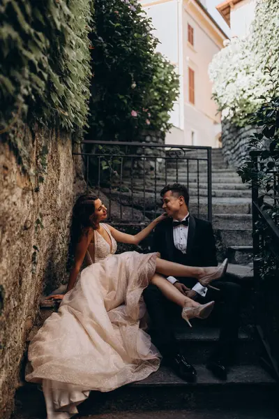 Eski kasabadaki merdivenlerde poz veren mutlu genç bir çiftin portresi.                           