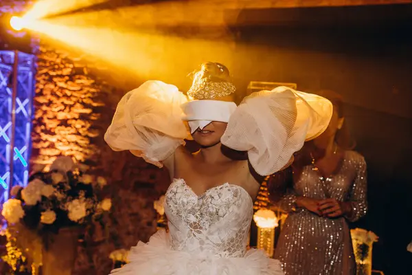 Partide gözleri kapalı dans eden gelinlik içindeki çekici genç gelin.