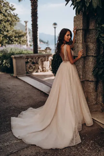 Beyaz gelinlikli güzel gelin eski kasaba caddesinde poz veriyor.                