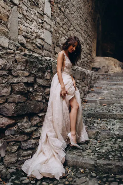 Gelinlikli güzel gelinin portresi. Eski kasabadaki merdivenlerde poz veriyor.                       