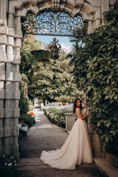 Beyaz gelinlikli güzel gelin eski kasaba caddesinde poz veriyor.                