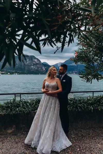 Mutlu gelin ve damat çifti gölün arka planında poz veriyor..