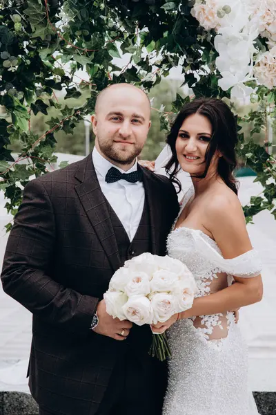 Mutlu gelin ve damat kameraya gülümsüyor.