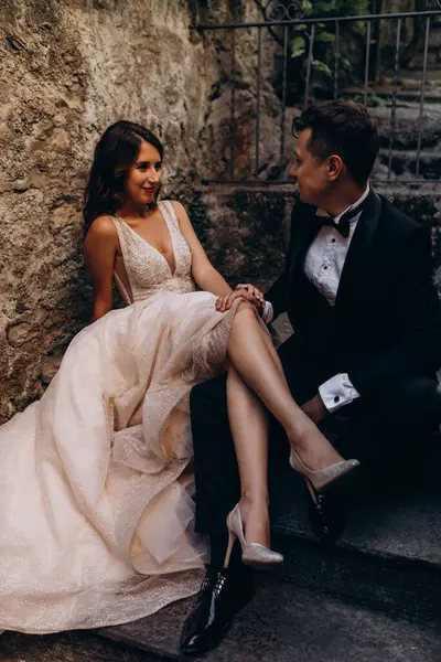 Eski kasabadaki merdivenlerde poz veren mutlu genç bir çiftin portresi.                           