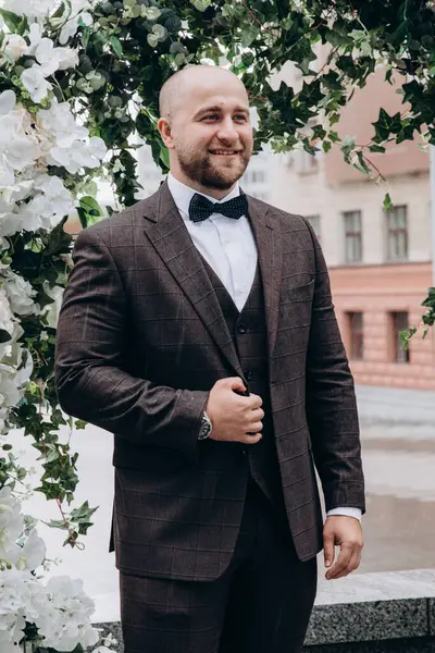 Zarif takım elbiseli ve papyonlu yakışıklı genç damat portresi.     