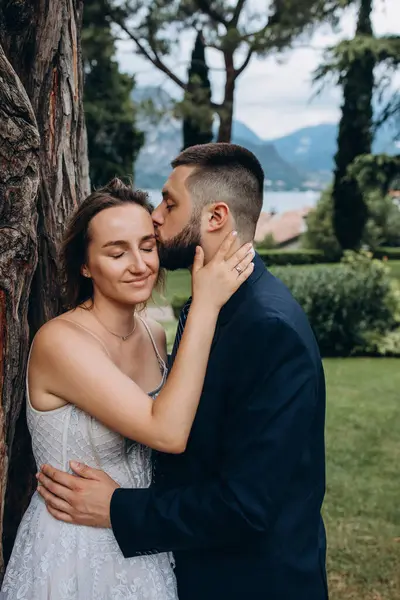 Güzel mutlu gelin ve damat parkta kucaklaşıyorlar.      