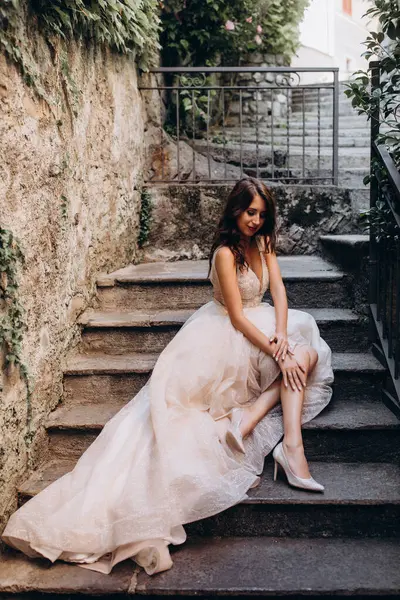 Gelinlikli güzel gelinin portresi. Eski kasabadaki merdivenlerde poz veriyor.                       