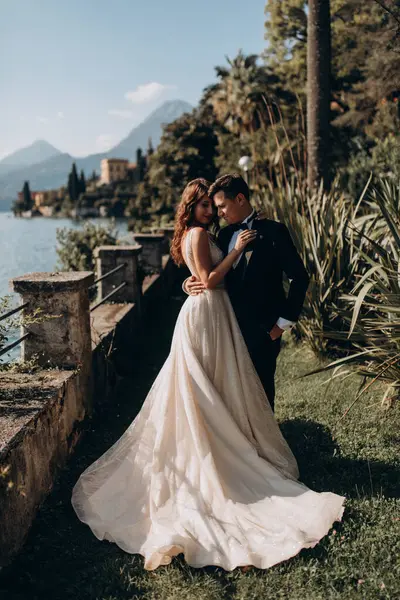 Güzel mutlu gelin ve damat parkta kucaklaşıyorlar.      