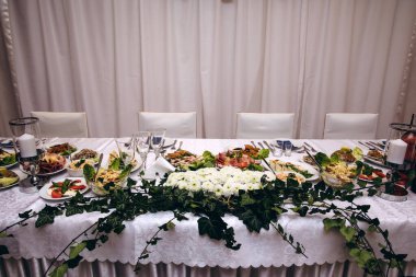 Düğün resepsiyonunda çiçeklerle süslenmiş güzel bir masa.                   