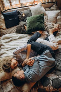 Mutlu çift sıcak bir stüdyoda yatakta uzanıyor. 