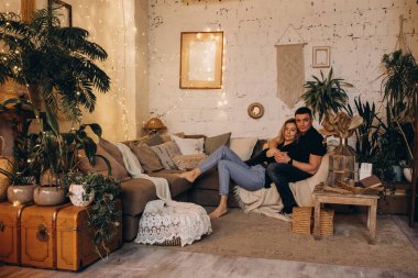 Güzel, mutlu, genç bir çift evde birbirine sarılıyor.     