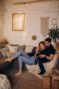 Güzel, mutlu, genç bir çift Noel dekoruyla rahat bir odada aşık.                    