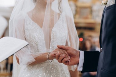 Gelin ve damadın düğün töreninde el ele tutuşurken kesilen görüntüleri.