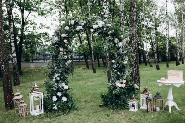 Açık hava düğün töreni için güzel çiçeklerle süslenmiş zarif kemer.       