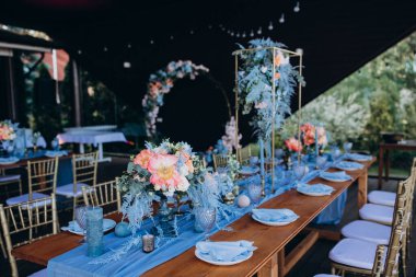 Restoranda çiçeklerle süslenmiş zarif bir düğün masası.                                